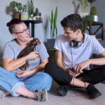 Happy talking mom and teenage son, parent and child sitting at home on the floor