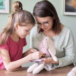 Mother and daughter child play together at home