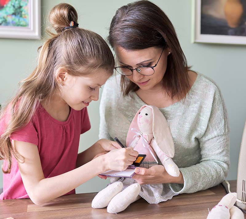 Mother and daughter child play together at home